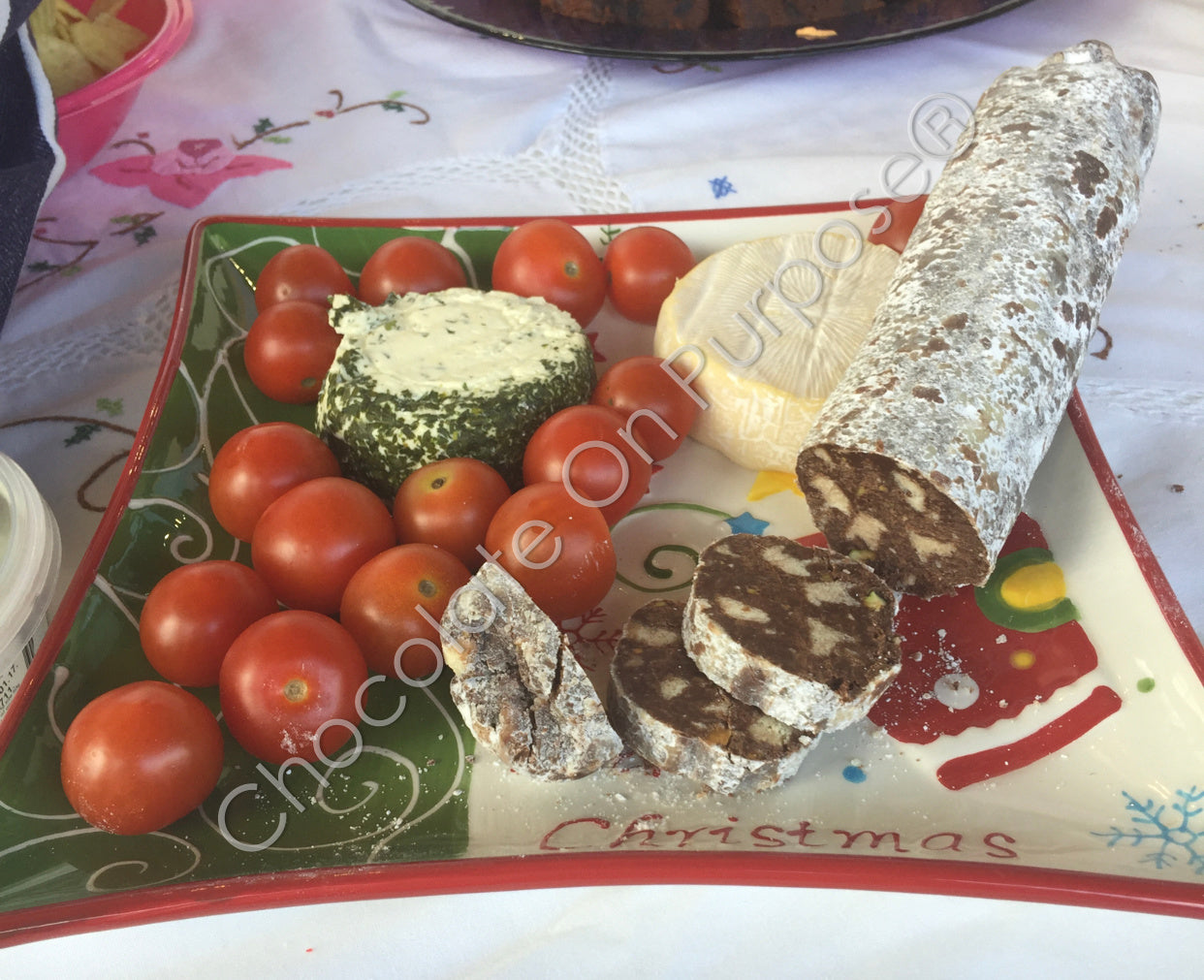 CHILLI Chocolate Salami cut up on charcuterie platter with cheese and tomatoss