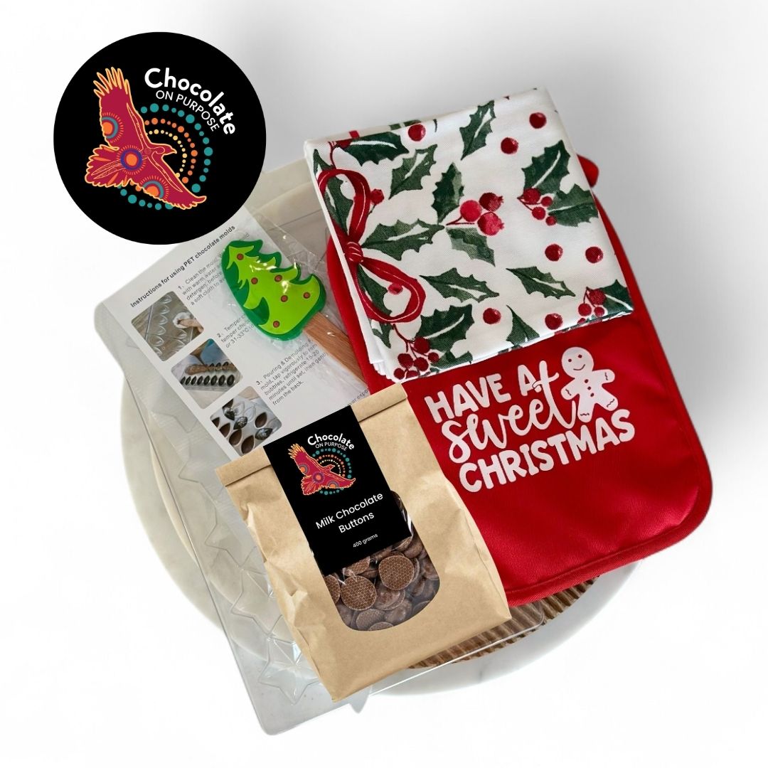 Christmas Chocolate Making Kit flatlay display showing Belgian Couverture chocolate with star chocolate mold with clear cavities, red pot holder with 