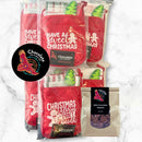 Five red Chocolate On Purpose® Christmas chocolate making kits displayed together, each featuring white festive text ("Have a Sweet Christmas" & "Christmas Calories Don't Count"), with gingerbread man and Christmas tree designs visible. Kits include Dindima (star) chocolate moulds with 12g cavity imprints, tea towels, piping bags, and 400g Belgian Callebaut couverture chocolate. Indigenous-owned, Fair Trade certified, Cocoa Horizons certified. Perfect for families, and work teams fun