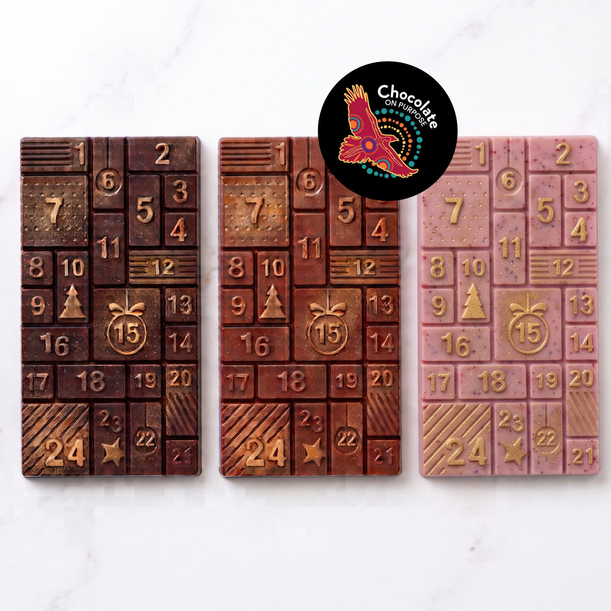 Warruyarra (to count in Wiradjuri language) chocolate advent calendar bars in dark chocolate with Gulalung (finger lime), milk chocolate with Munthari (muntrie berry) and white chocolate with Ooray (Davidson plum), each with 24 numbered windows and gold lustre. Chocolate On Purpose logo of Eagle, with Spirit within.