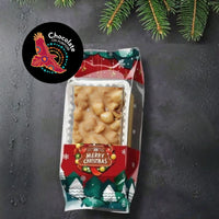 Murru Malang golden rocky road chocolate packaged in festive Christmas candy bag with clear window, red and green holiday design, snowflakes, Christmas trees, and Merry Christmas label. Chocolate On Purpose logo badge displayed