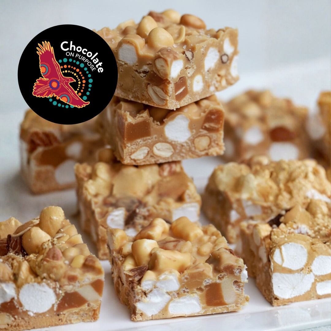 Murru Malang golden caramelised rocky road chocolate stacked in three layers showing marshmallows, peanuts, and sea salt. Chocolate On Purpose logo badge displayed. Product photography on white background.