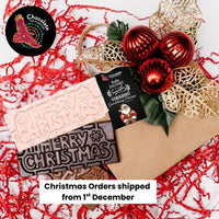 Chocolate On Purpose 'Merry Christmas Gift Hamper Bag' with three chocolate bars, White Chocolate with Ooray (Davidson Plum) and Milk Chocolate with Munthari (Muntrie Berry) and Dark Chocolate with Gulalung (Finger Lime), bag decorated with embellishment of red baubles & gold holly leaves with Babiin Ngungghi (Father of Giving) Gift Tag and Chocolate On Purpose Logo stamp. With message that Christmas Orders shipped from 1st December.