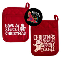 Red quilted pot holders with white festive text, "Have a Sweet Christmas" and "Christmas Calories Don't Count", gingerbread man designs, red hanging loop, Chocolate On Purpose Christmas chocolate making kit component, heat-resistant fabric, Indigenous-owned ethical gifting