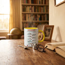 Chocolate On Purpose NAIDOC 2026 ceramic mug with yellow handle on worn timber desk beside reading glasses open book and framed photo with warm bookshelf and globe in background