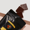Bag of Dark Chocolate Riberra with three chocolate pieces falling out.